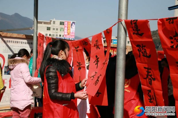 活动现场，书法爱上者现场写春联并赠予当地群众
