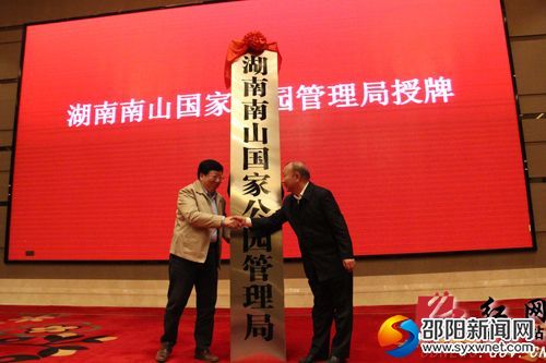 图为2017年10月13日上午,湖南省委常委、常务副省长、湖南南山国家公园体制试点领导小组组长陈向群(左)在邵阳市为湖南南山国家公园管理局授牌,湖南南山国家公园管理局党委书记、城步县委书记罗建南(右)接牌 (刘令摄)