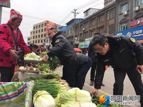 路政队员正在帮摊贩搬离“马路市场”