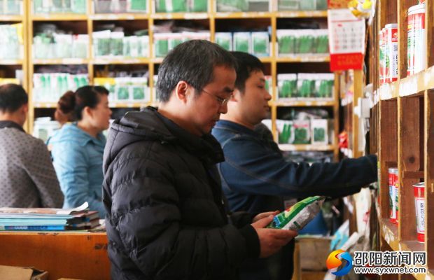 市种子管理处工作人员正在检查一家经营网点的种子质量