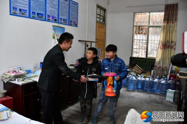 “爱心车队”队员将学习用品送到特困学生手中
