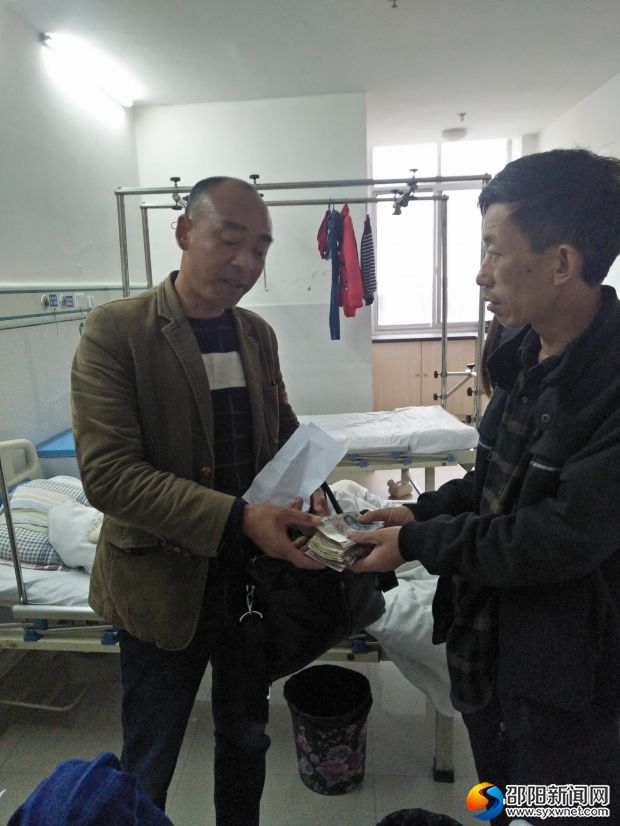 学校总务将爱心款交给病人家长