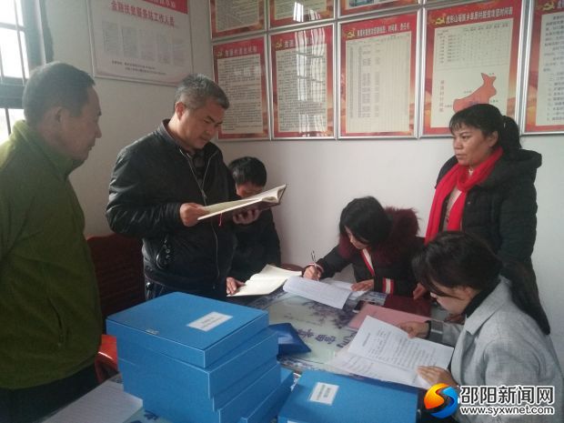 袁愈绍(左二)查看草原村党支部基层党建“一本通”