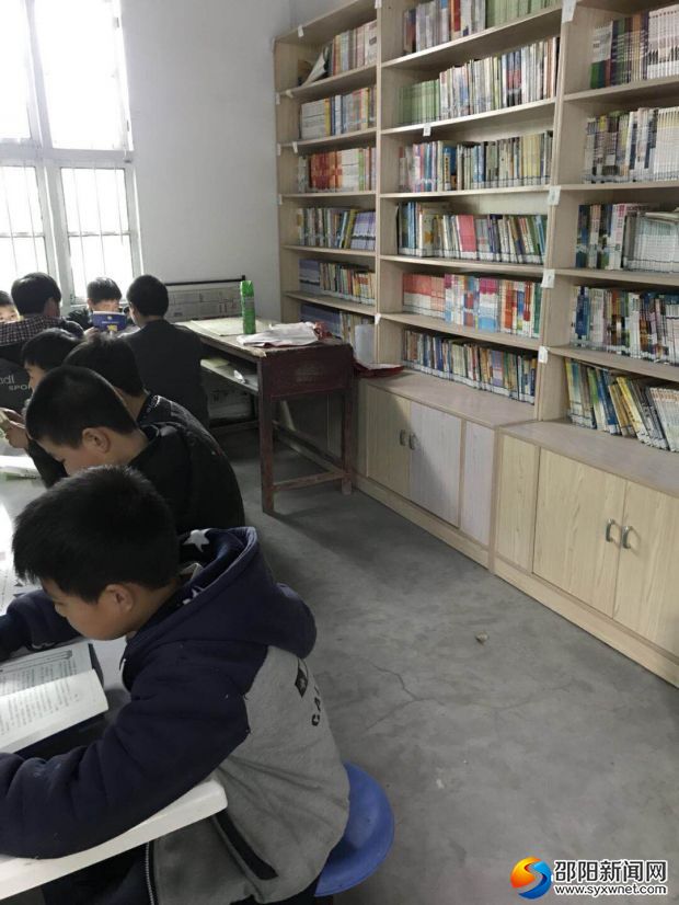 图为学校图书馆及孩子们全神贯注读书的场景!