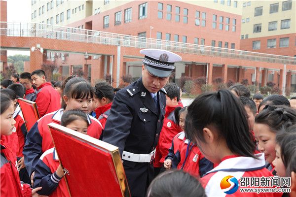 图为孩子们观看交通安全宣传展板