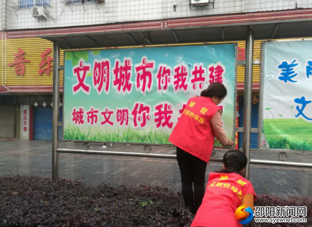 城管志愿者整理创文宣传栏