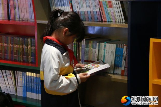 高撑小学校园共享书店内,一名学生正沉浸在知识的海洋里