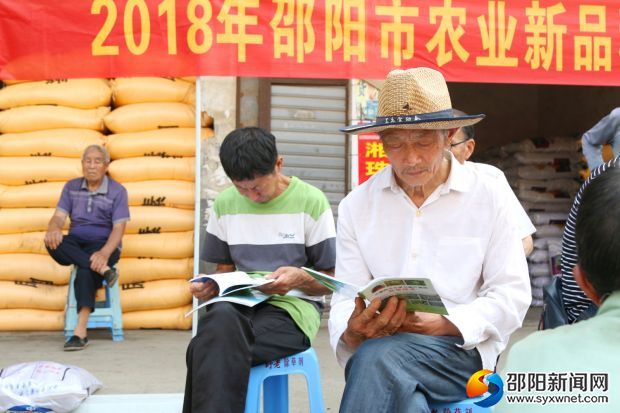 农户正在认真学习科普资料中关于蔬菜种植的知识
