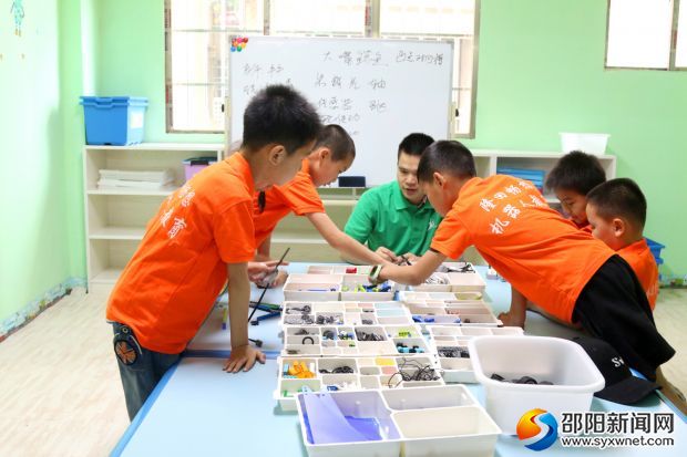 老师正在指导孩子组装教具