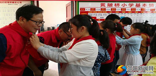 黄陂桥小学的少先队员们仔细地为党员志愿者们系上红领巾