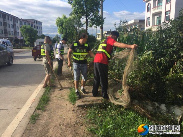 新宁县路政队员正在清除路肩农作物