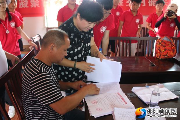 松坡图书馆馆长李洁与河沿村支书刘志辉签订合同