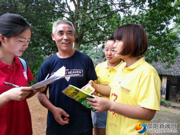 图为同老人做问卷调查普及用药知识
