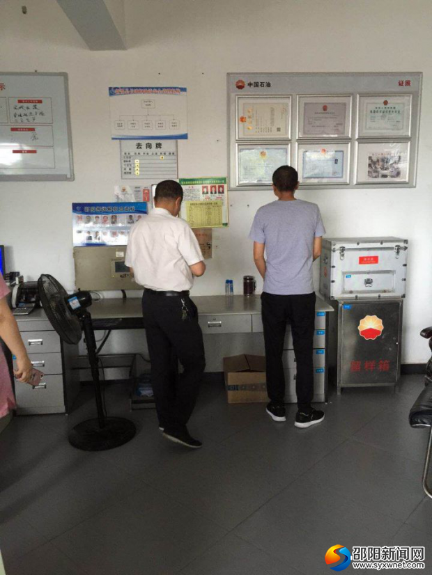 图为执法人员正在中石油旗下超市检查证照是否齐全