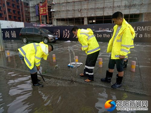 县公用事业局工作人员正在清理雨水井口周边垃圾