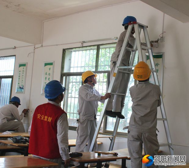 工作人员帮助学校更换老旧线路、修理开关插座