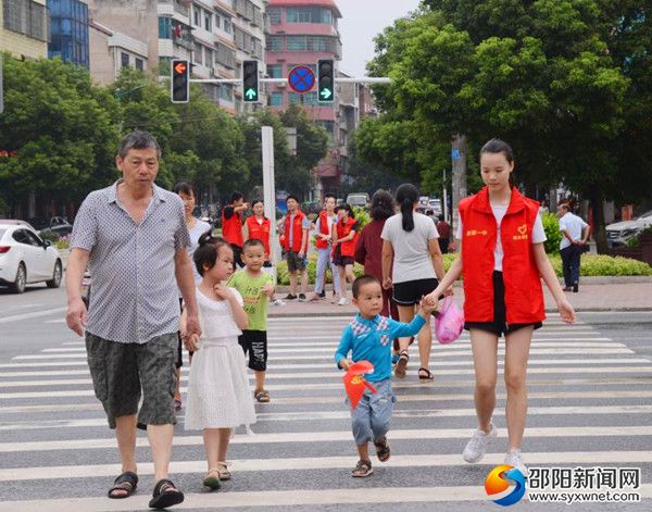 志愿者引导小孩过马路