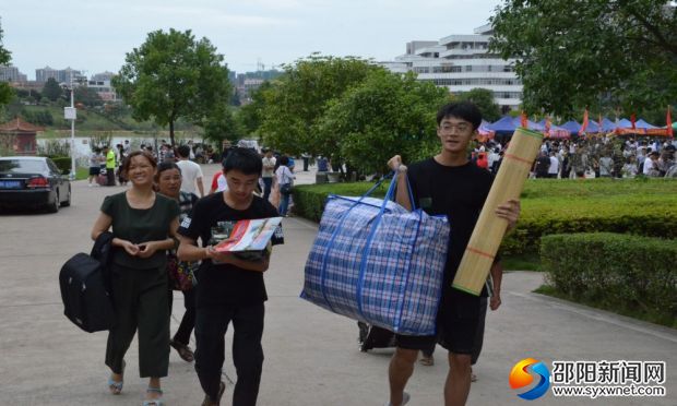 迎新工作人员帮新生帮运行李