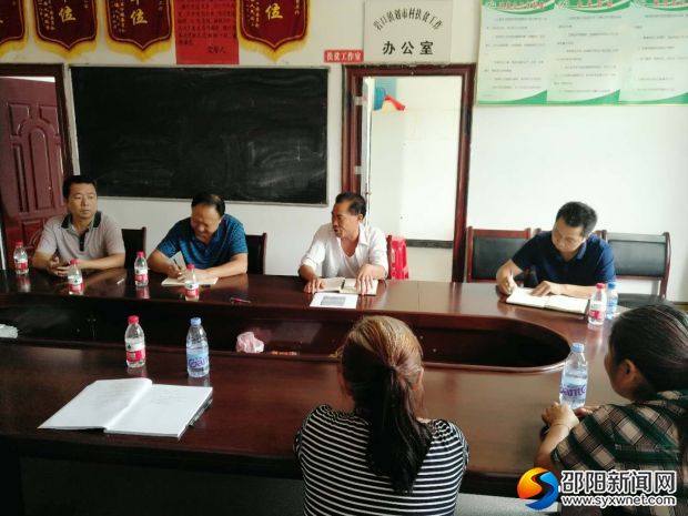 图为赵旭红校长(前右一)、李柏树书记(前右三)正在听取划市村扶贫工作情况介绍。
