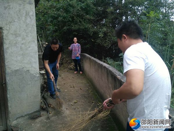 林业局扶贫工作人员协助贫困户打扫环境卫生