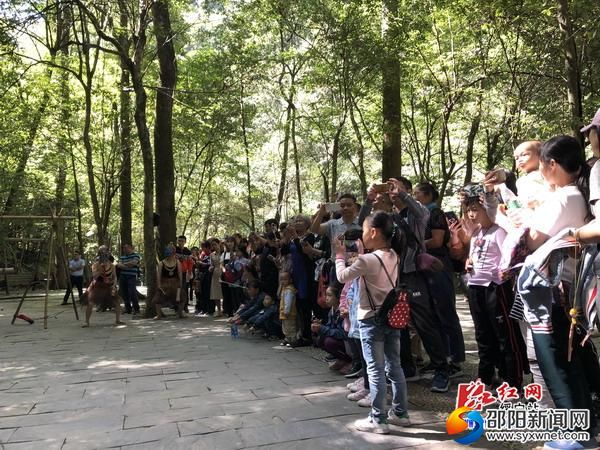 游客围在一起观看民俗表演。