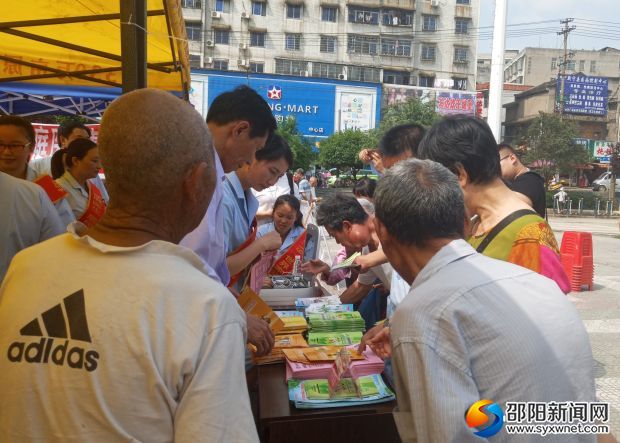 图为:医务人员在义诊活动中向群众宣传反邪教知识