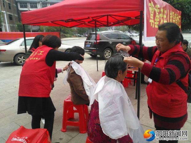 图为志愿者为老人理发