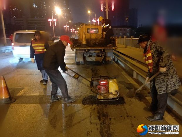 （图：1月31日晚，该局养护工人避开车流高峰对资江一桥桥面进行坑槽修补工作）