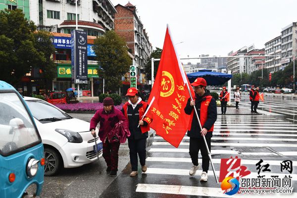 小小交通文明劝导员扶老人过马路。