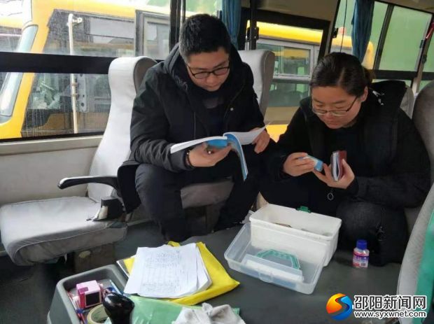 图为检查校车随车记录资料及医药箱情况