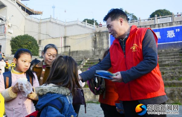 志愿者向学生发放宣传资料。