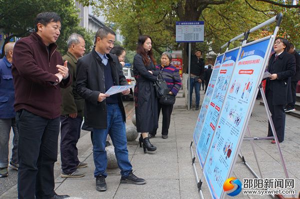 过往群众仔细了解宣传展板内容。
