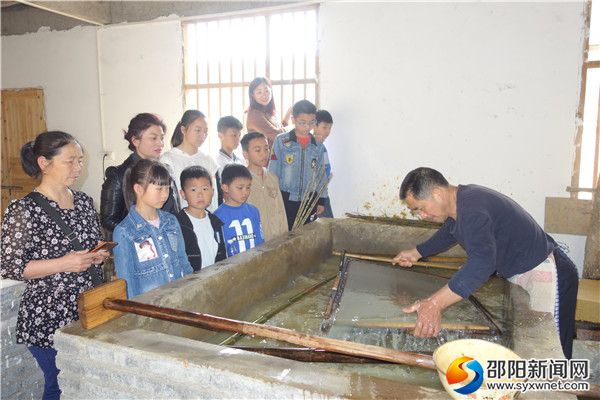 一、隆回县雨山中心学校罗小英老师（二排左一）：组织该校中小学生、万和实验学校学生，以及家长代表，在滩头手工抄纸作坊参观李志军艺人抄纸。DSC06670
