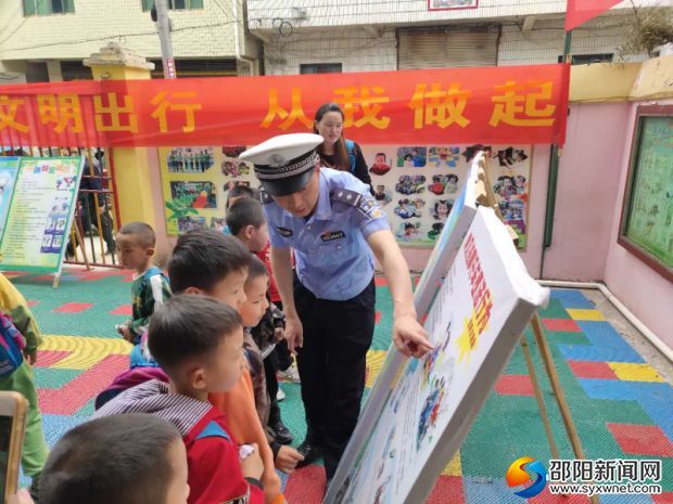 带领孩子们观看并讲解道路交通安全知识宣传展板