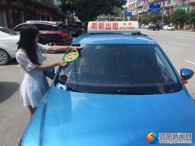 城步昕昕出租车公司员工为车辆张贴&ldquo;爱心送考&rdquo;标志