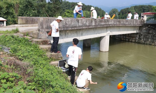 勘察团队在收集水样,测量桥梁信息