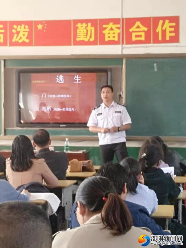 图为何教官正在为老师们讲授火灾中的逃生知识