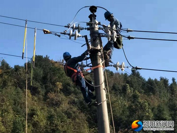 图为潭府供电所配电班员工李国祥和李晓雄在小团年支线安装横担和瓷瓶。(拍摄者:戴玮炜)