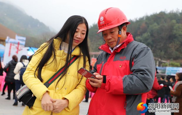 图为国网邵阳供电公司员工周永良在向客户介绍掌上电力APP使用方法。(摄影 刘雄英)