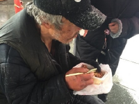 流浪老人北京街头吃雪 好心路人买饭送衣