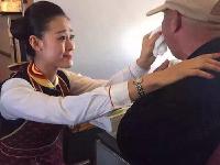 河南老人飞机上无法进食 空姐跪地喂饭