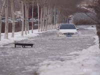 长春一道路积水成“冰河” 一天陷住近20辆车