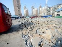 济南停车场路面被砸碎 80辆公交车停路边