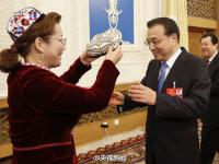 李克强参加新疆代表团审议 代表为其戴花帽