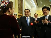 李克强参加新疆代表团审议 代表为其戴花帽
