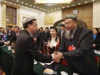 李克强参加新疆代表团审议 代表为其戴花帽