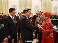 李克强参加新疆代表团审议 代表为其戴花帽