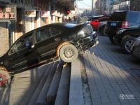 吉林街头现奇葩停车 轿车倾斜停一米高台上