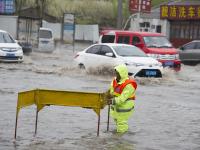 长春暴雨 市政工人站排水口一天防止事故