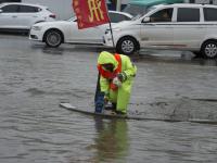 长春暴雨 市政工人站排水口一天防止事故